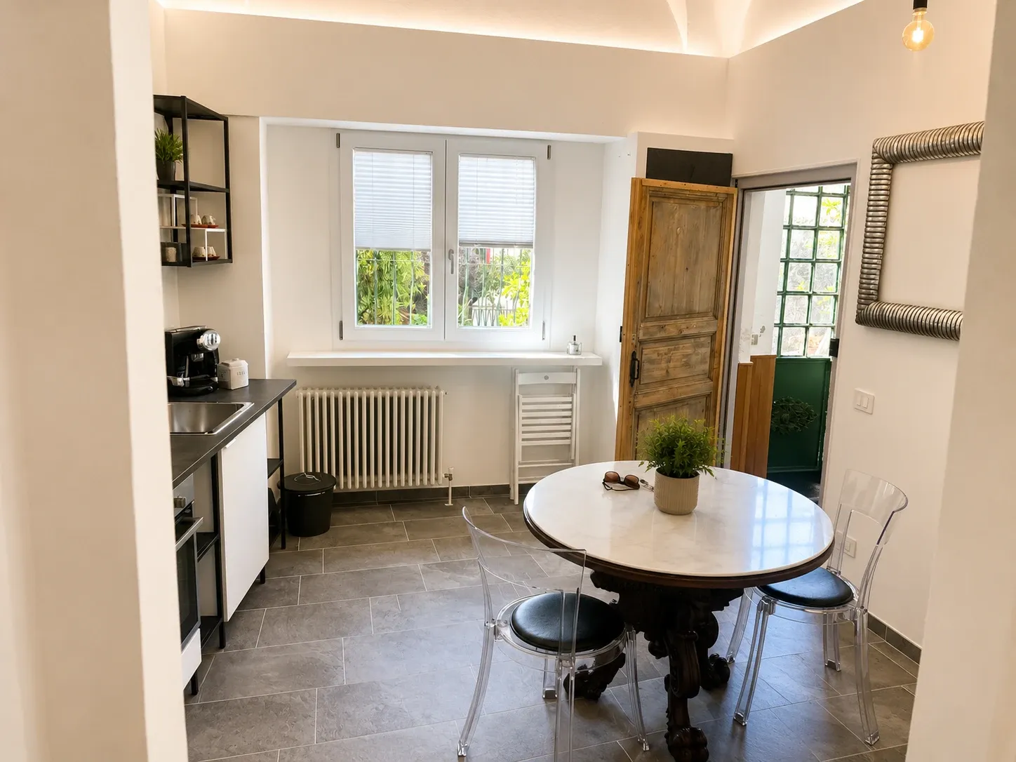Cucina e zona pranzo di Ca del Lac con tavolo rotondo e porta antica